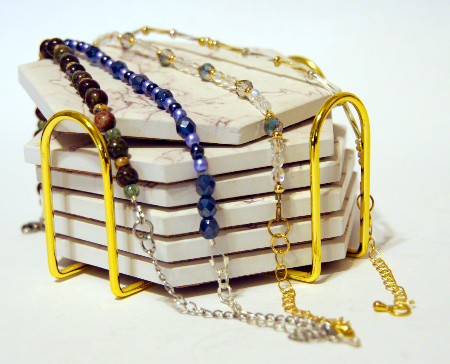 Photograph of four different bracelets draped across coasters